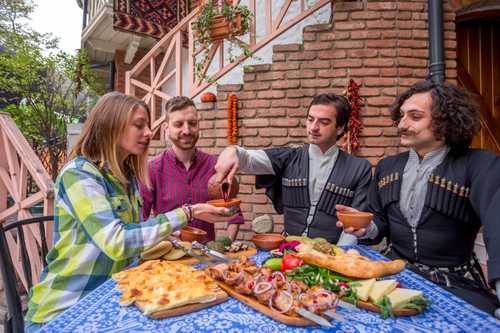 Georgian festive table, people drink wine and eat together