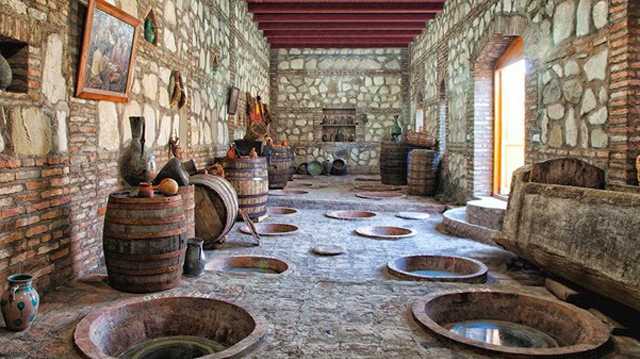 Clay vessels and barrels in a historical wine cellar in Georgia